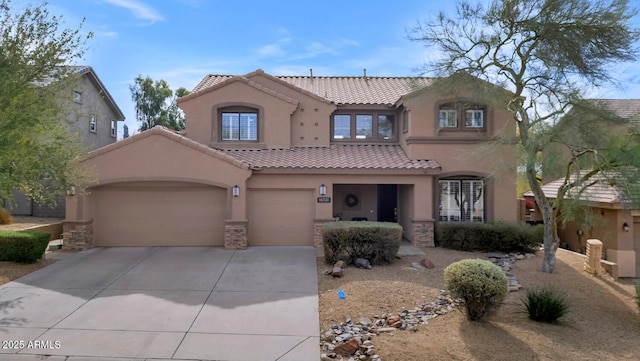 mediterranean / spanish-style home featuring a garage, a tile roof, concrete driveway, stone siding, and stucco siding