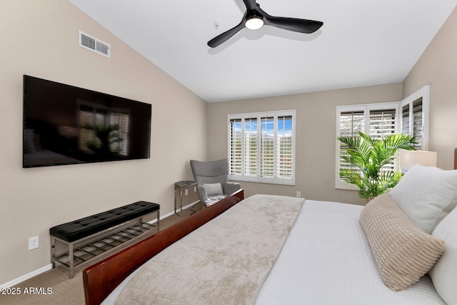 carpeted bedroom with lofted ceiling, baseboards, visible vents, and a ceiling fan