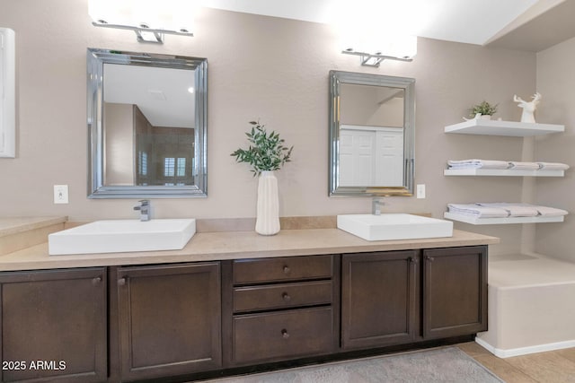 full bath featuring double vanity, tile patterned flooring, and a sink