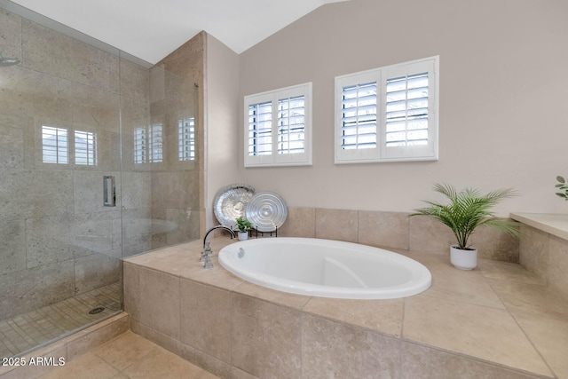 full bath featuring vaulted ceiling, a shower stall, a bath, and tile patterned floors