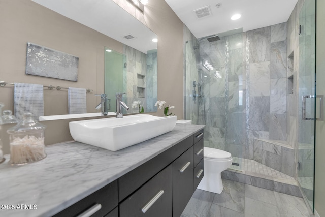 bathroom featuring marble finish floor, visible vents, toilet, a stall shower, and vanity