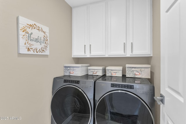 washroom featuring washing machine and dryer and cabinet space