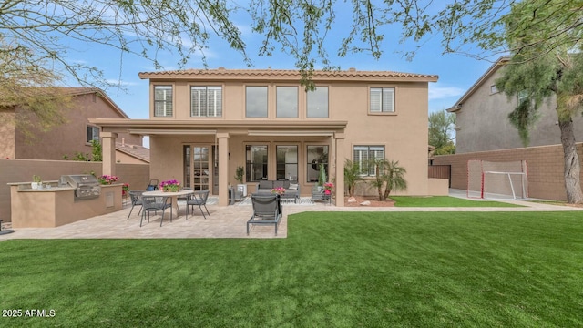 rear view of house featuring a patio, fence, area for grilling, and stucco siding