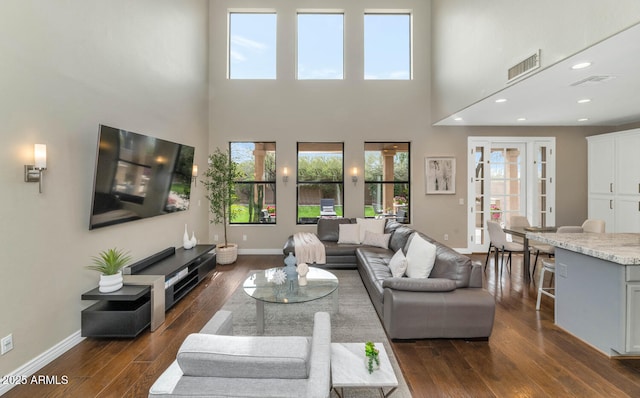 living room with dark wood-style floors, a healthy amount of sunlight, visible vents, and baseboards