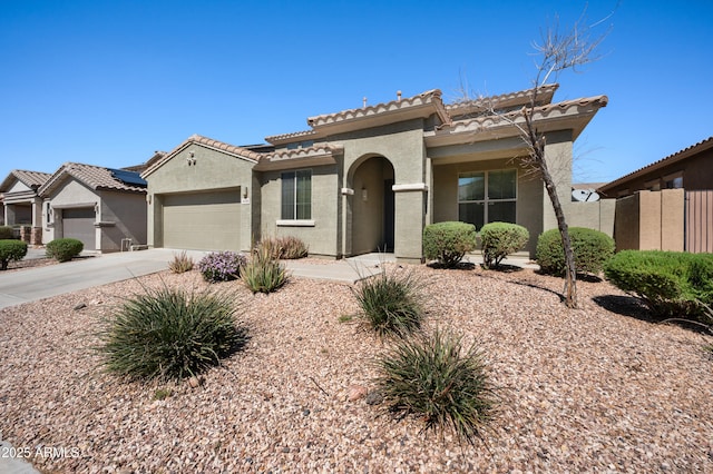 mediterranean / spanish home with a tiled roof, stucco siding, driveway, and an attached garage