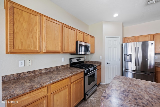 kitchen featuring recessed lighting, visible vents, dark countertops, and appliances with stainless steel finishes