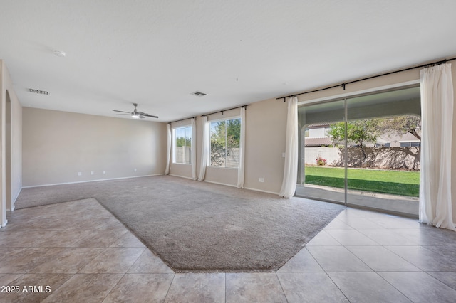unfurnished room with light tile patterned floors, visible vents, baseboards, and ceiling fan