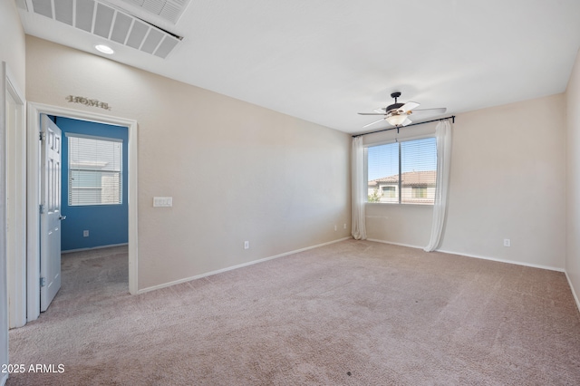 spare room with baseboards, visible vents, carpet floors, and ceiling fan