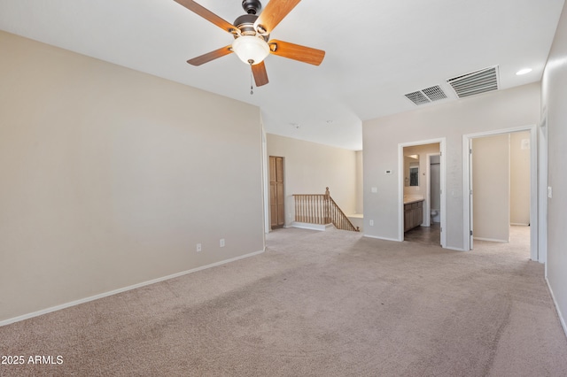 unfurnished room featuring light colored carpet, a ceiling fan, visible vents, and baseboards