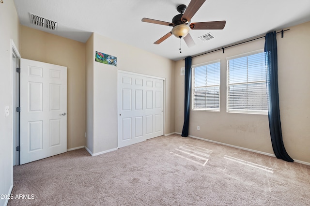 unfurnished bedroom featuring a closet, visible vents, a ceiling fan, and carpet