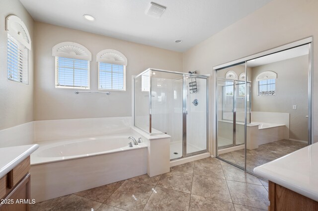 bathroom featuring a stall shower, a bath, and vanity