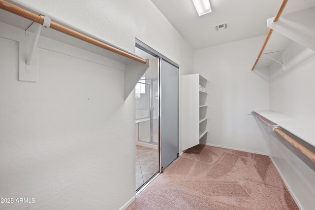 spacious closet with light colored carpet and visible vents