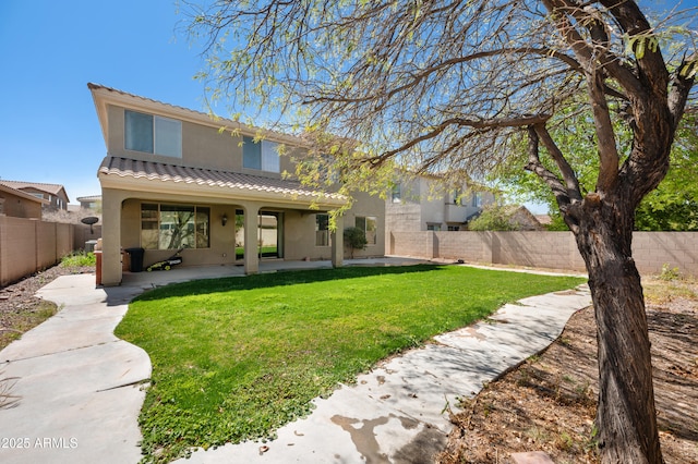 back of property featuring a patio, a fenced backyard, stucco siding, a tiled roof, and a lawn