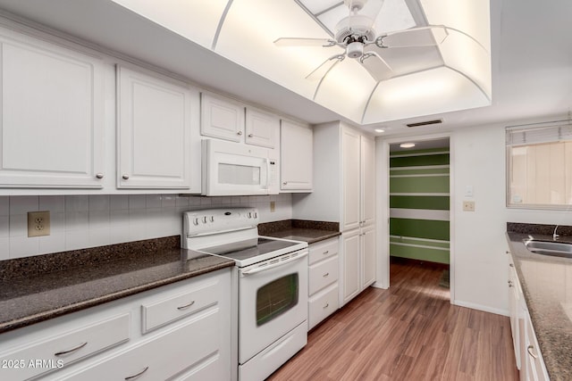 kitchen with light wood finished floors, visible vents, decorative backsplash, white cabinetry, and white appliances