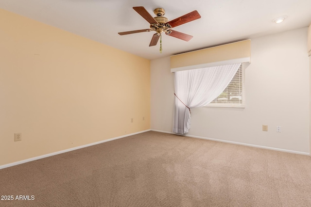 carpeted empty room with ceiling fan and baseboards