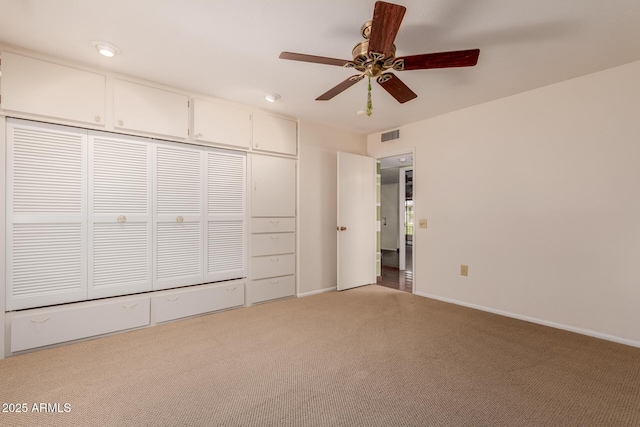 unfurnished bedroom with visible vents, baseboards, a closet, and light colored carpet