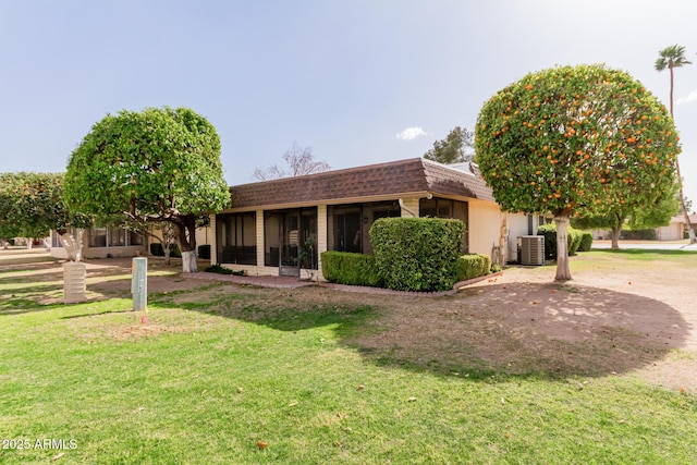 view of front of house featuring a shingled roof, a front yard, central air condition unit, and mansard roof