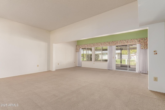 carpeted spare room featuring high vaulted ceiling