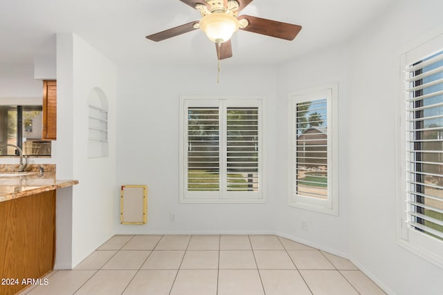 spare room with sink, ceiling fan, and light tile patterned floors