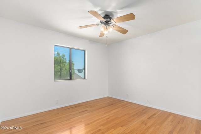 empty room with ceiling fan and light hardwood / wood-style flooring