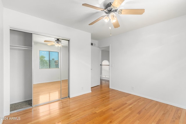 unfurnished bedroom featuring a closet, light wood-type flooring, and ceiling fan