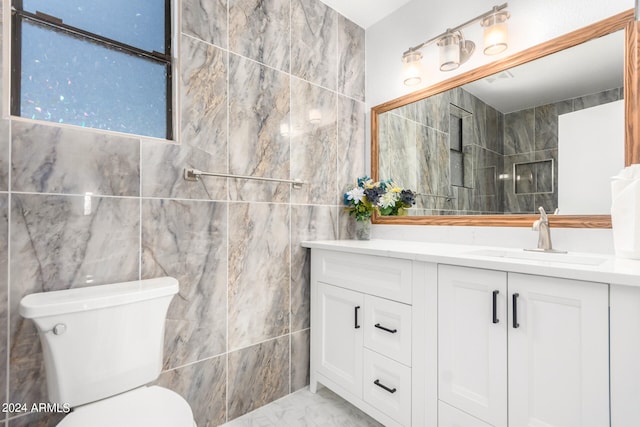 bathroom with tile walls, tile patterned floors, toilet, and vanity