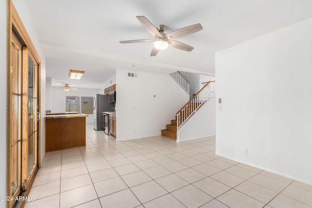 unfurnished living room featuring light tile patterned floors and ceiling fan