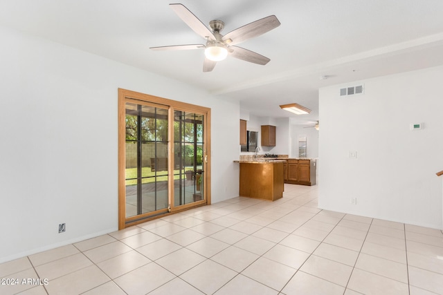 tiled empty room featuring sink and ceiling fan