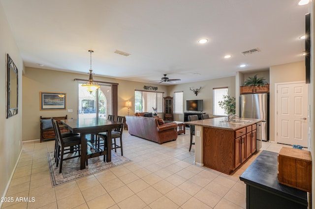 4975 W Gulch Dr, Eloy, AZ 85131 - kitchen featuring brown cabinetry, freestanding refrigerator, a sink, and visible vents