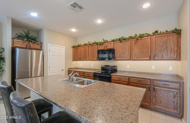 4975 W Gulch Dr, Eloy, AZ 85131 - kitchen with visible vents, a sink, a kitchen breakfast bar, brown cabinetry, and black appliances