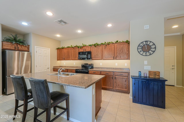 4975 W Gulch Dr, Eloy, AZ 85131 - kitchen with a breakfast bar, black appliances, visible vents, brown cabinets, and a sink