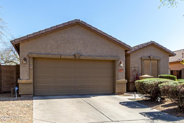 ranch-style home with a garage, fence, concrete driveway, and stucco siding