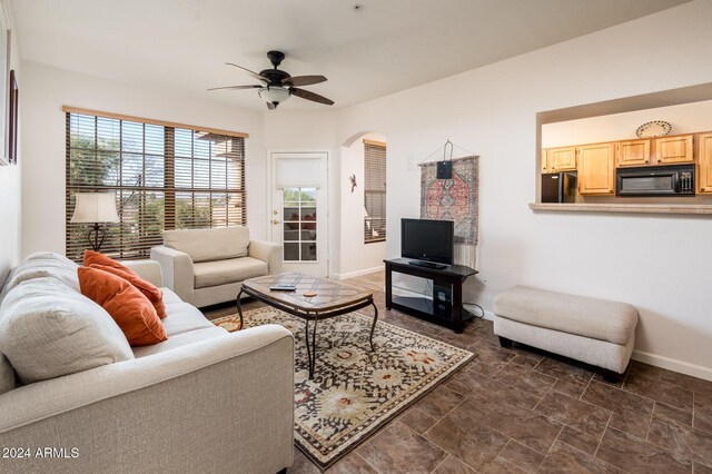 14950 W Mountain View Blvd Unit 1305, Surprise, AZ 85374 - living area featuring baseboards, arched walkways, ceiling fan, and dark stone finish floors