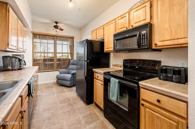 kitchen featuring light brown cabinetry, ceiling fan, black appliances, tile counters, and light tile patterned flooring