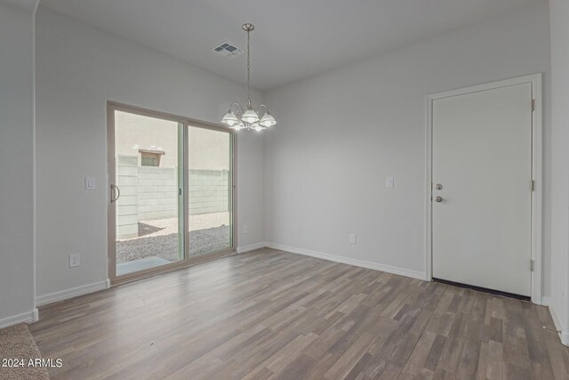 812 E Agua Fria Ln, Avondale, AZ 85323 - unfurnished room with baseboards, visible vents, wood finished floors, and a chandelier