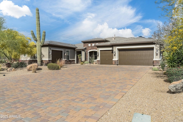 35971 N Prickley Pear Rd, Cave Creek, AZ 85331 - prairie-style house with stone siding, an attached garage, decorative driveway, and stucco siding