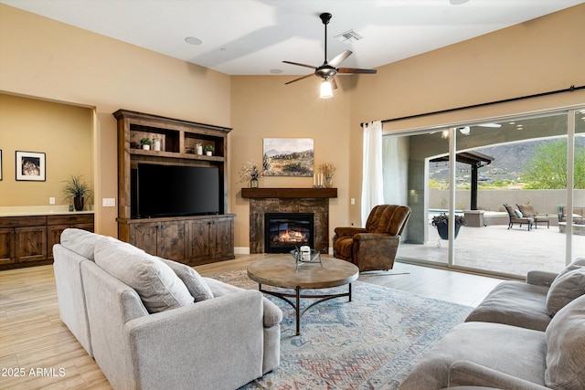 35971 N Prickley Pear Rd, Cave Creek, AZ 85331 - living area with a glass covered fireplace, ceiling fan, light wood-style floors, and a towering ceiling