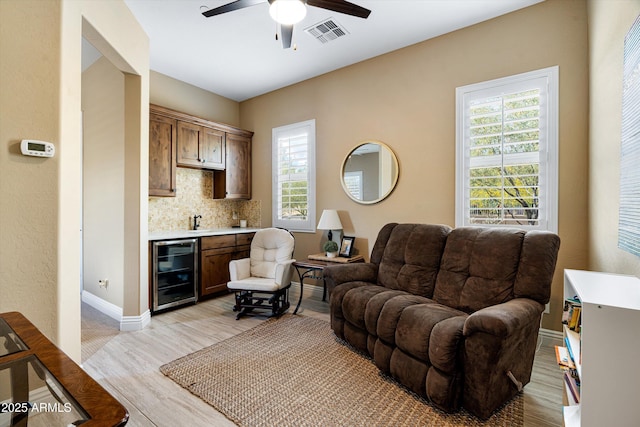 35971 N Prickley Pear Rd, Cave Creek, AZ 85331 - living room with beverage cooler, ceiling fan, healthy amount of natural light, and light wood-type flooring