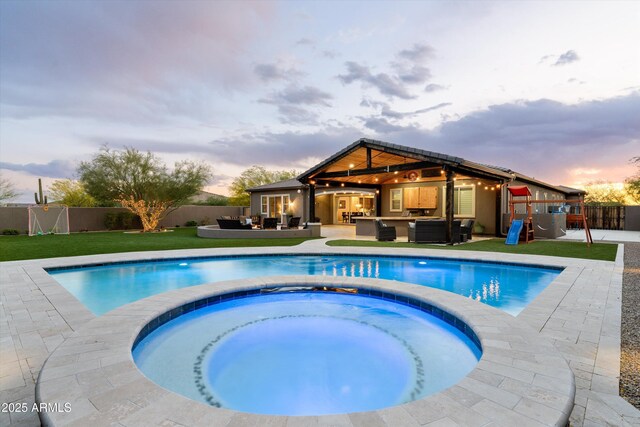 35971 N Prickley Pear Rd, Cave Creek, AZ 85331 - pool at dusk featuring an outdoor living space, a fenced backyard, and a pool with connected hot tub