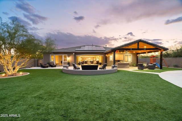 35971 N Prickley Pear Rd, Cave Creek, AZ 85331 - back of property at dusk featuring an outdoor living space, a patio area, roof mounted solar panels, and stucco siding