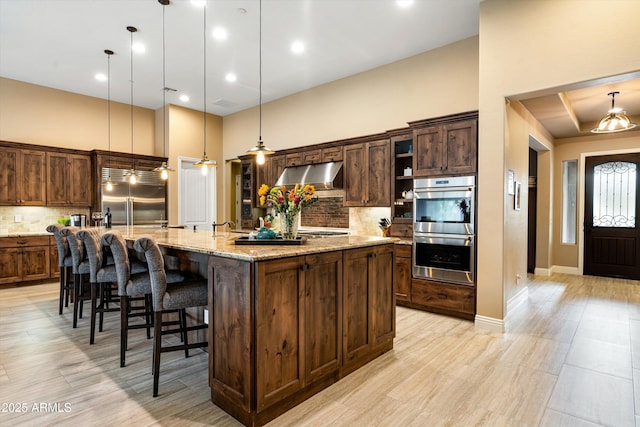 35971 N Prickley Pear Rd, Cave Creek, AZ 85331 - kitchen featuring stainless steel appliances, under cabinet range hood, decorative backsplash, a high ceiling, and a large island