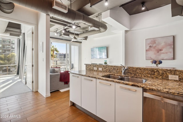 kitchen featuring sink, stone countertops, light hardwood / wood-style flooring, dishwasher, and white cabinetry