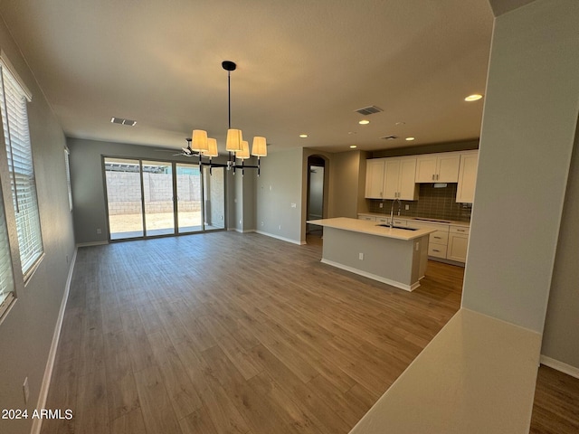 3375 W Verde River Rd, San Tan Valley, AZ 85144 - kitchen featuring open floor plan, a chandelier, wood finished floors, white cabinets, and a kitchen island with sink