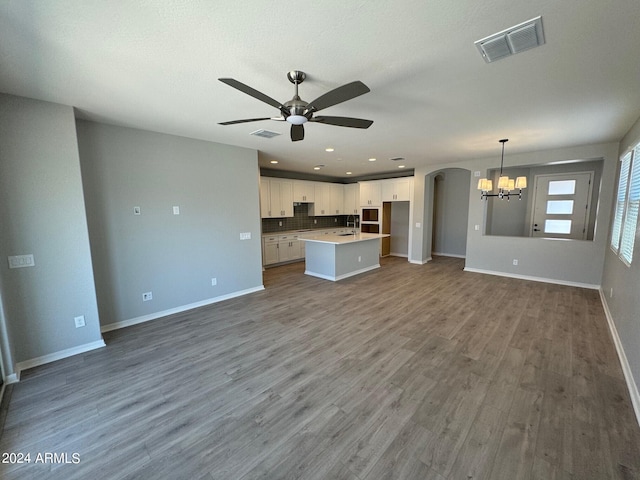 3375 W Verde River Rd, San Tan Valley, AZ 85144 - unfurnished living room with a chandelier, ceiling fan, dark wood-type flooring, arched walkways, and recessed lighting