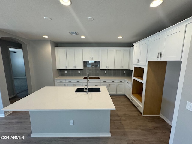 3375 W Verde River Rd, San Tan Valley, AZ 85144 - kitchen featuring a kitchen island with sink, decorative backsplash, dark wood-style floors, arched walkways, and white cabinetry