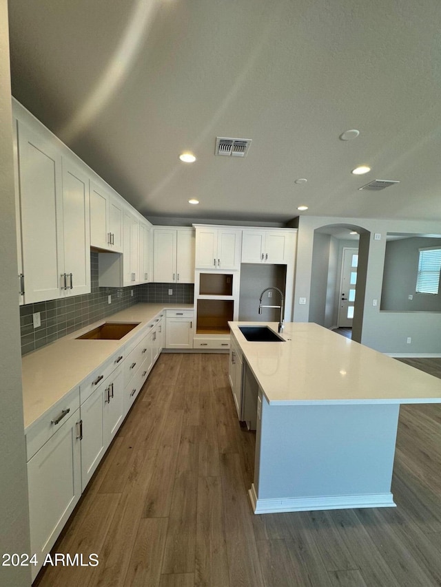 3375 W Verde River Rd, San Tan Valley, AZ 85144 - kitchen featuring dark wood finished floors, black electric stovetop, decorative backsplash, arched walkways, and white cabinetry