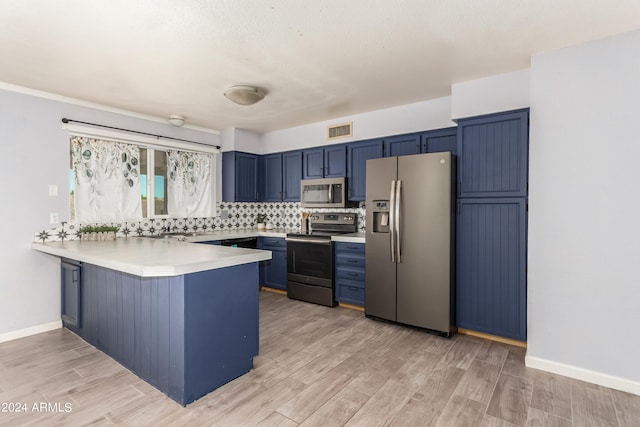 kitchen featuring blue cabinetry, appliances with stainless steel finishes, kitchen peninsula, and light wood-type flooring