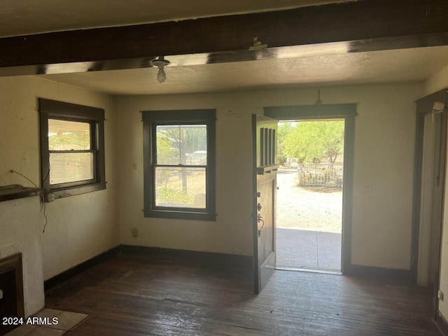 entryway featuring plenty of natural light, dark wood-type flooring, and beam ceiling