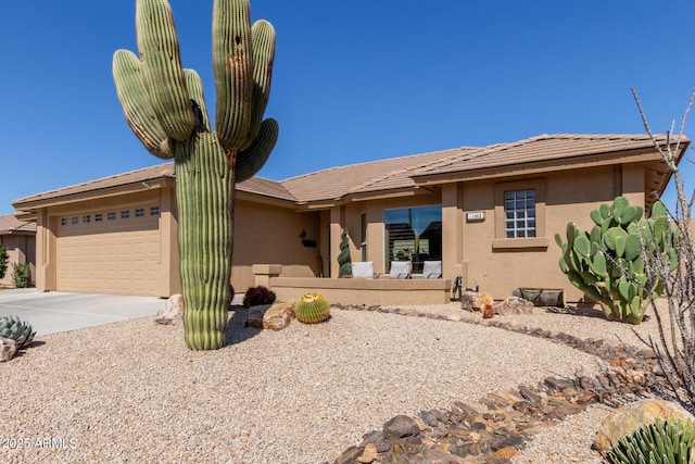 single story home with stucco siding, driveway, and a garage