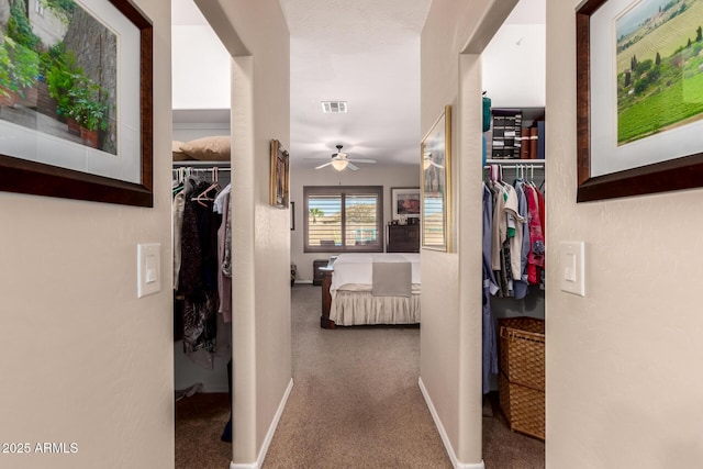 hallway with visible vents and baseboards